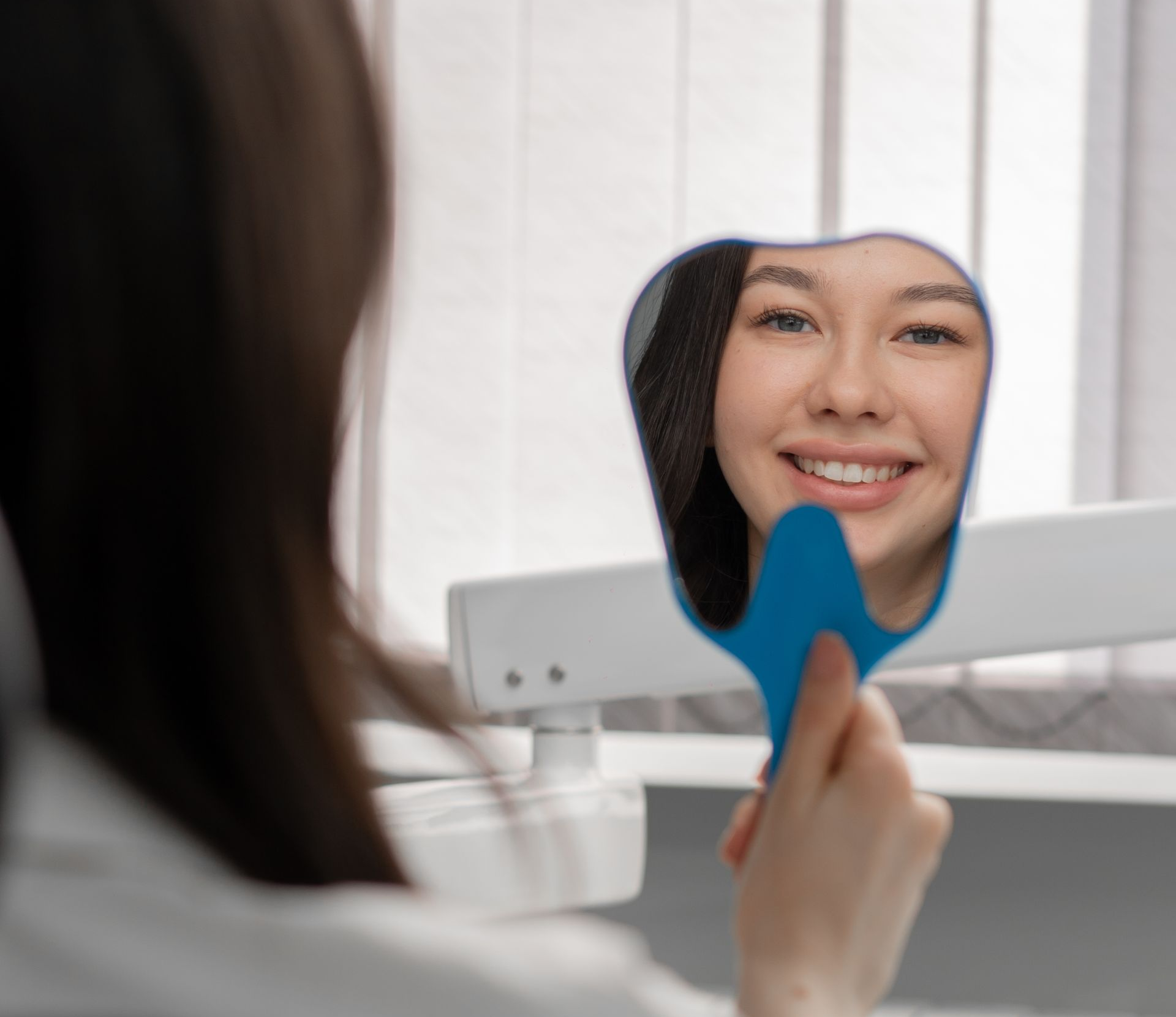 Natural-focused holistic dental care in Marrero, LA. A dentist is examining a woman 's teeth in a dental office.