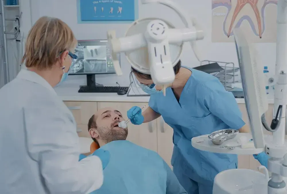 A dentist is examining a patient 's teeth in a dental office.