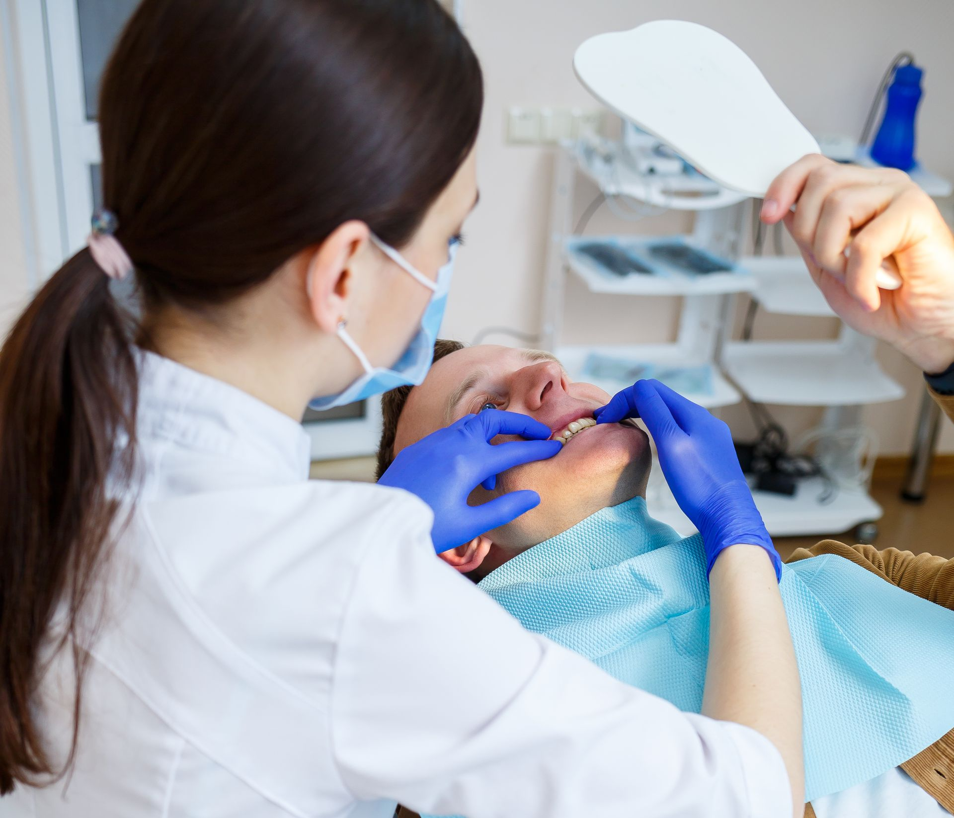 A woman is getting her teeth examined by a dentist.