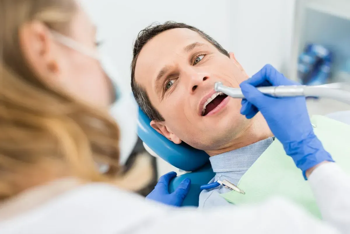 A man is getting his teeth examined by a dentist.