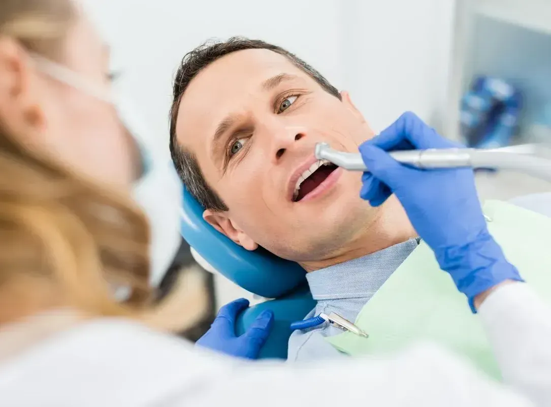 A man is getting his teeth examined by a dentist.