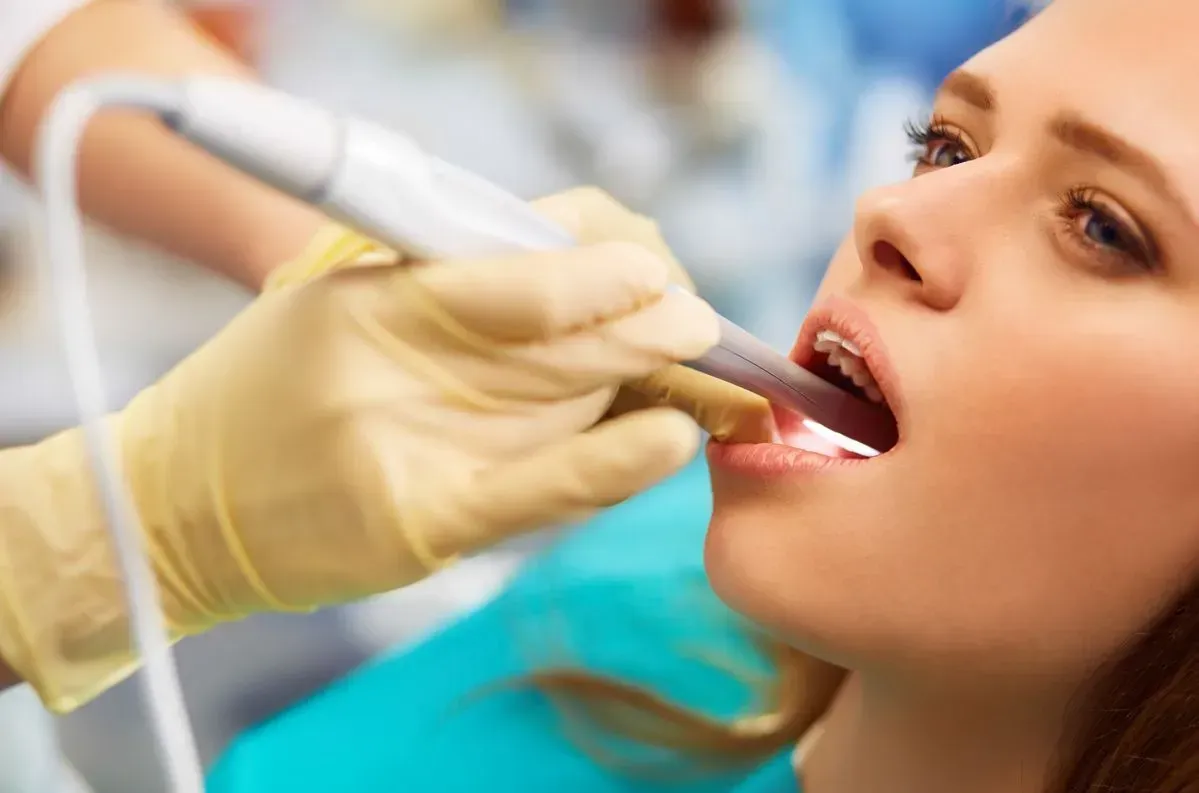 A woman is getting her teeth examined by a dentist.