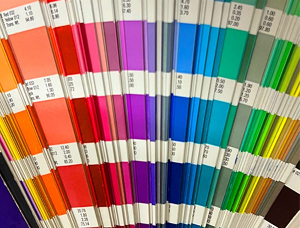 Color swatch fan deck displaying a range of vibrant hues, including orange, pink, purple, and green.