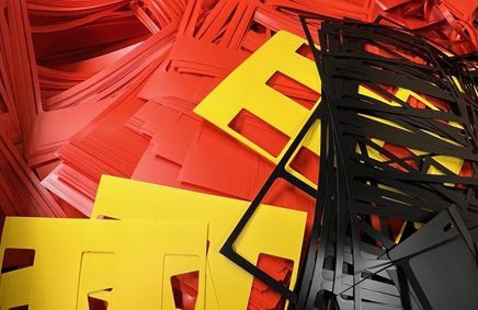 Red, yellow, and black letter stencils, likely for sign-making, are stacked.