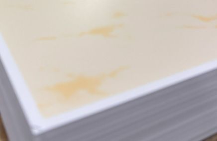 Pile of cream-colored paper with a small orange stain.