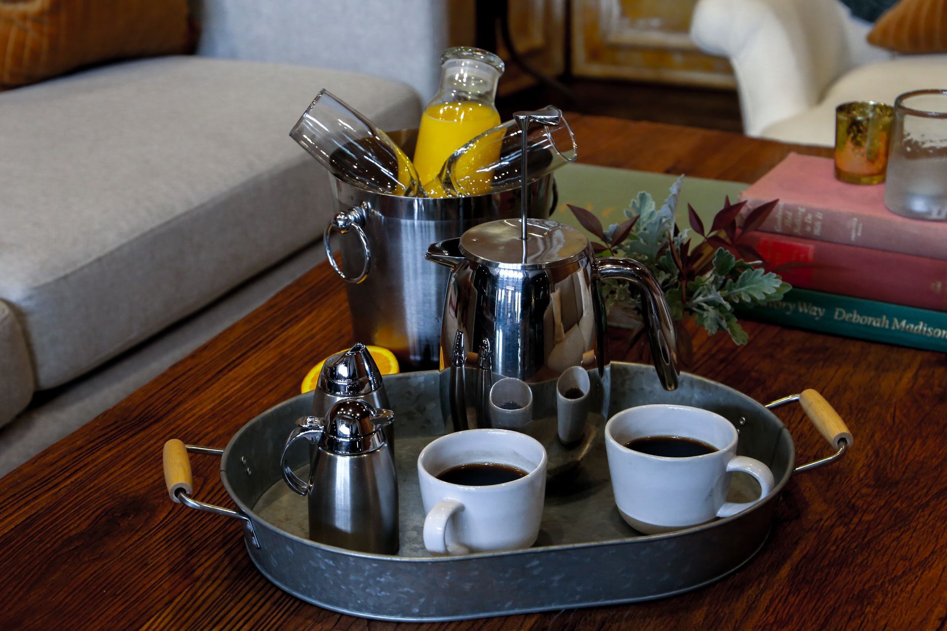 A tray with two cups of coffee and a bucket of orange juice