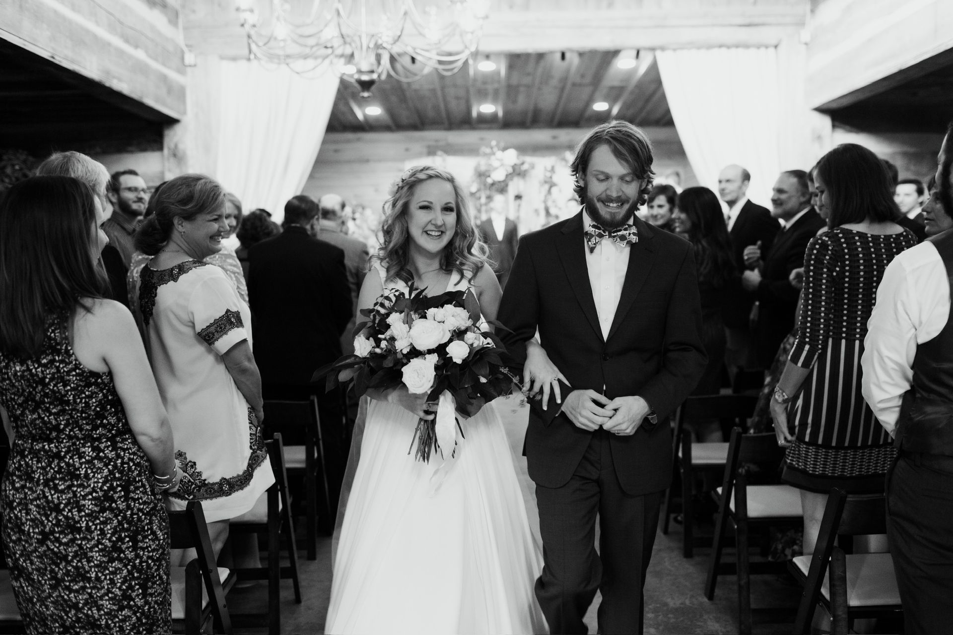 A bride and groom are walking down the aisle at their wedding.