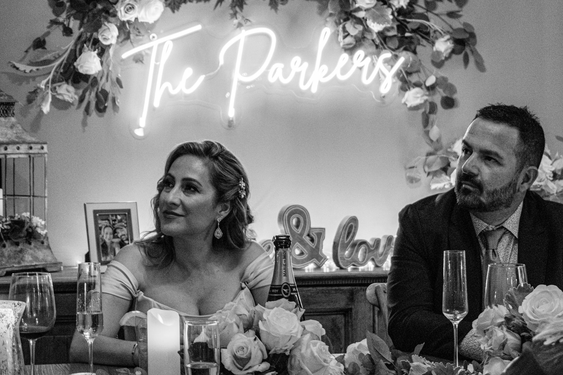A black and white photo of a bride and groom sitting at a table.