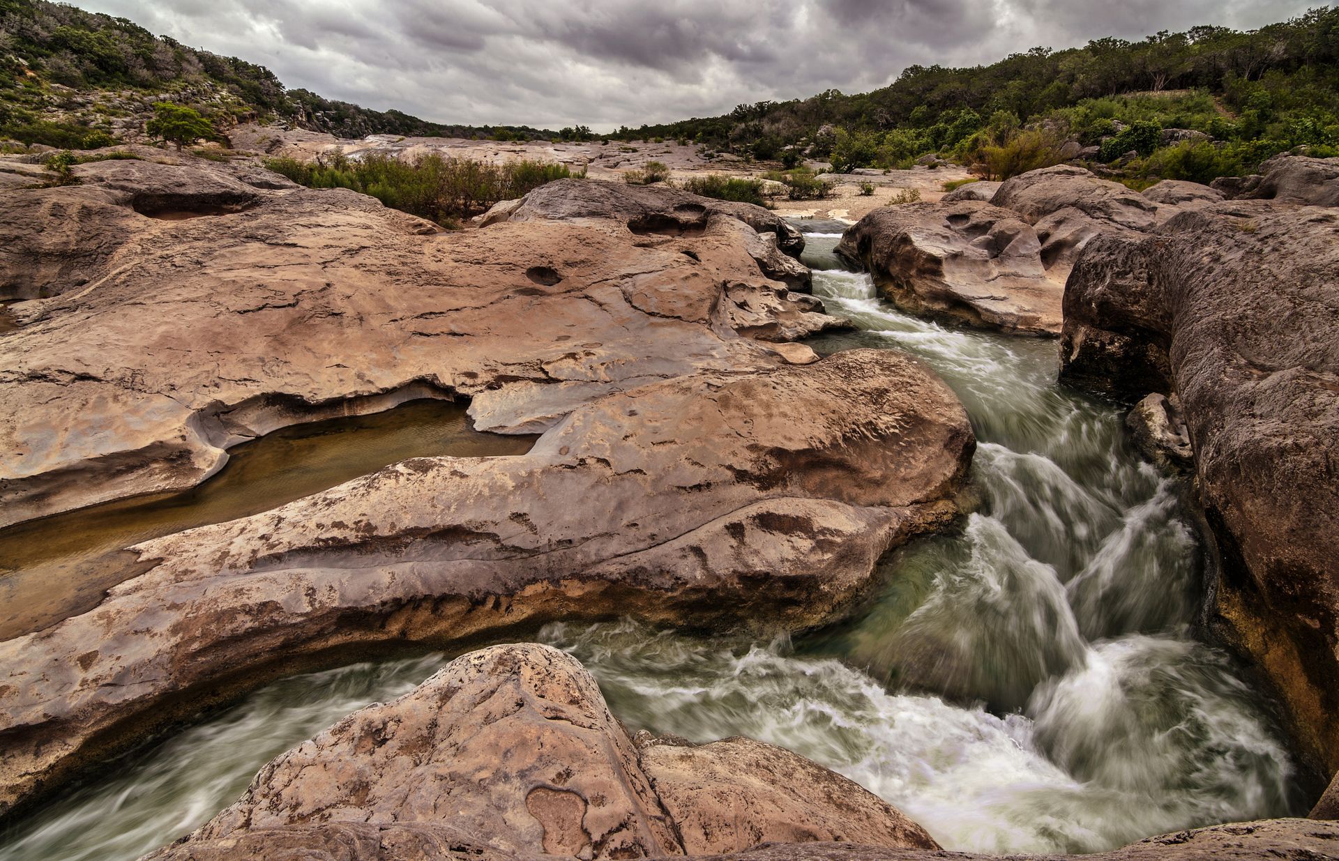 A river flowing through a canyon surrounded by rocks and trees.