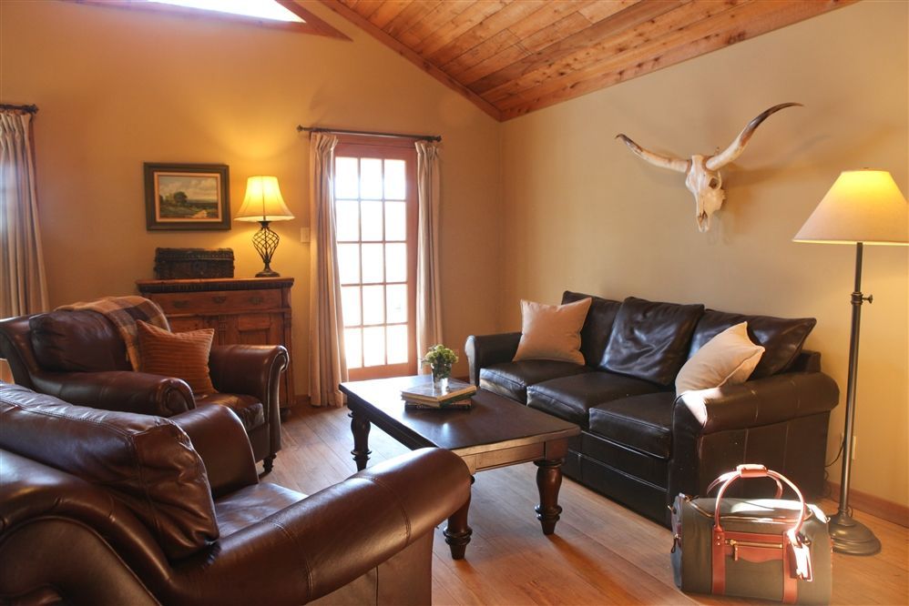 A living room with a couch and two chairs