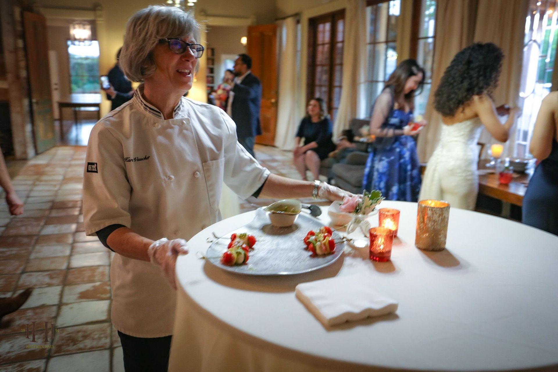 A woman is holding a tray of food on a table.