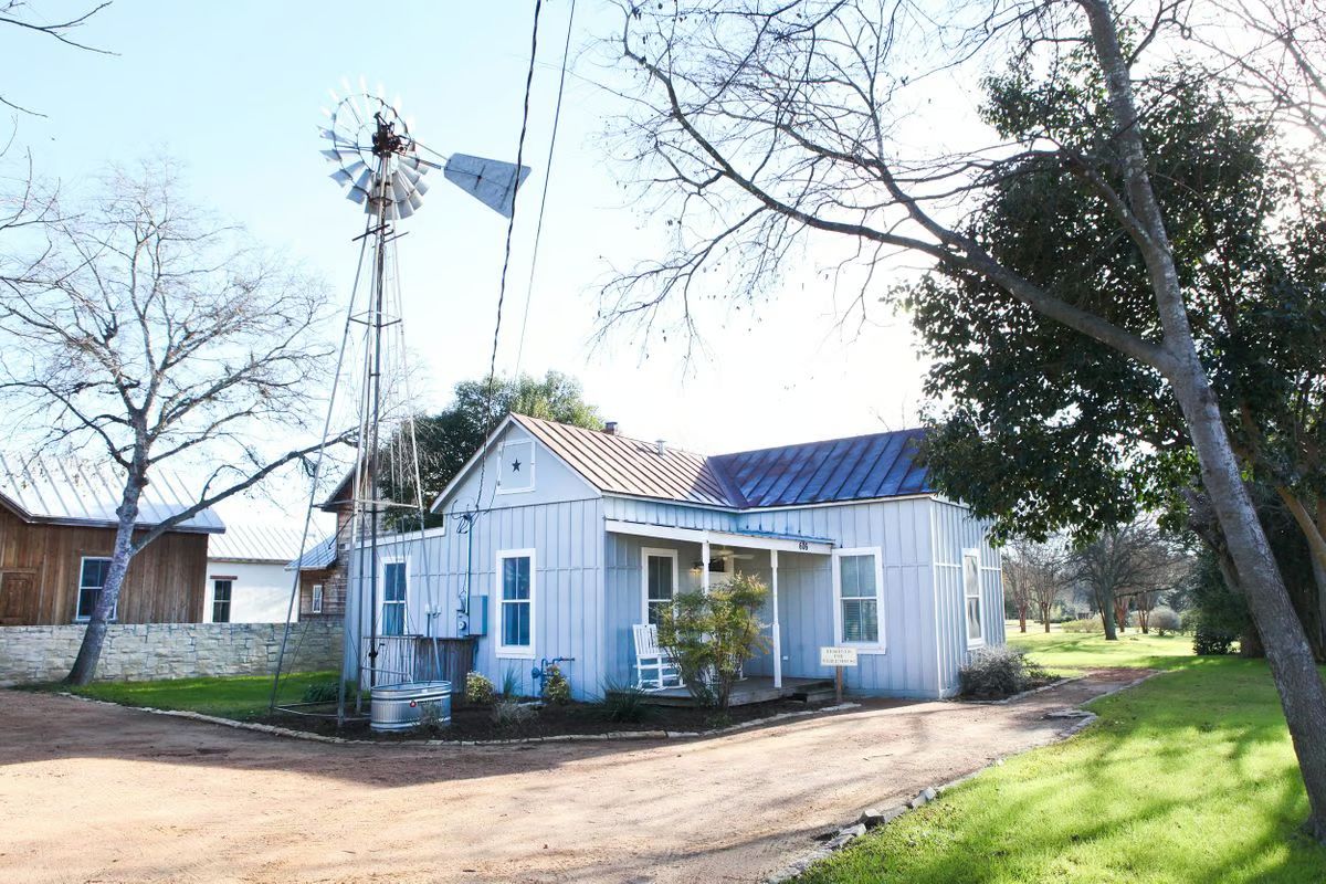 A white house with a windmill in front of it