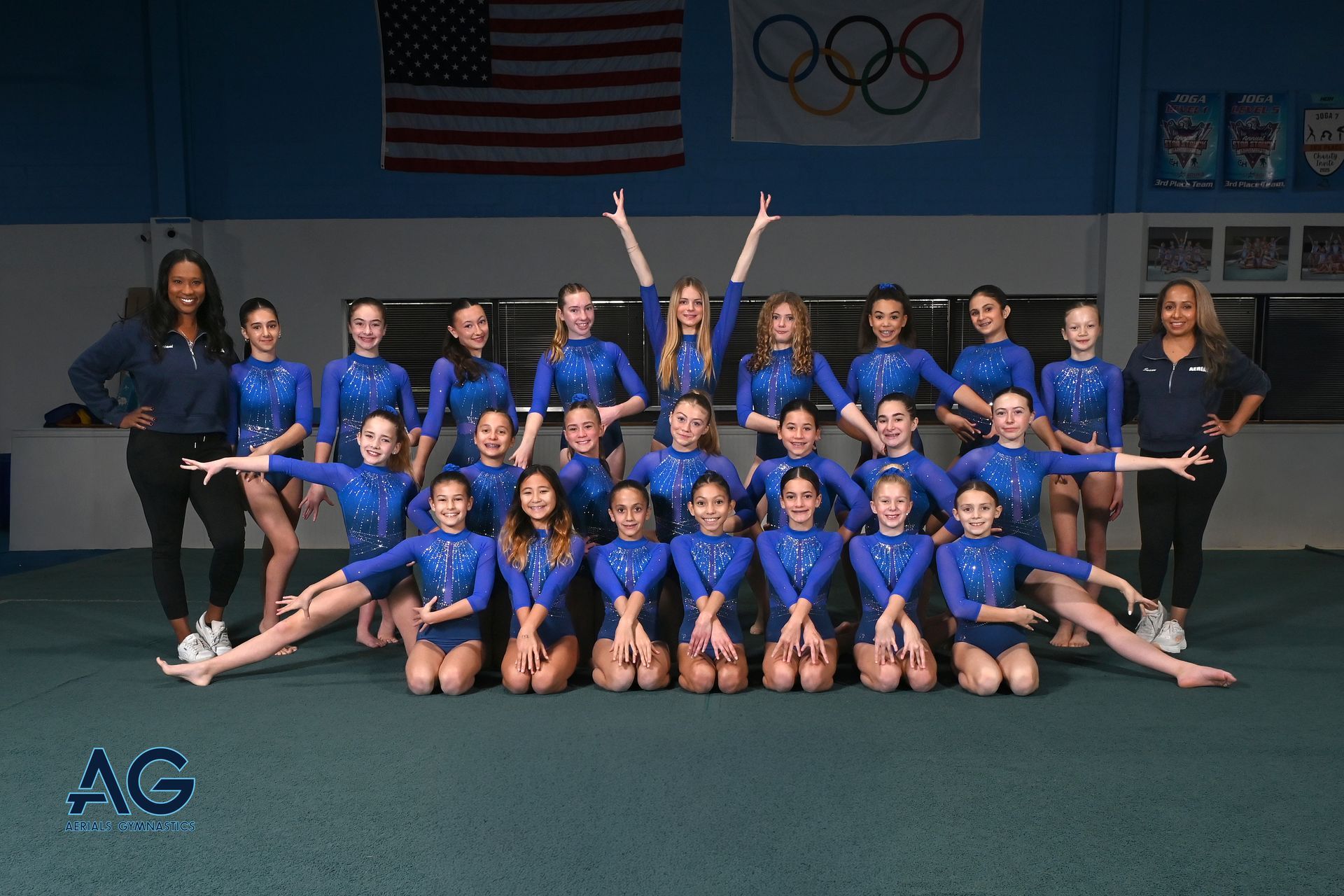 A female gymnast is standing on a balance beam.