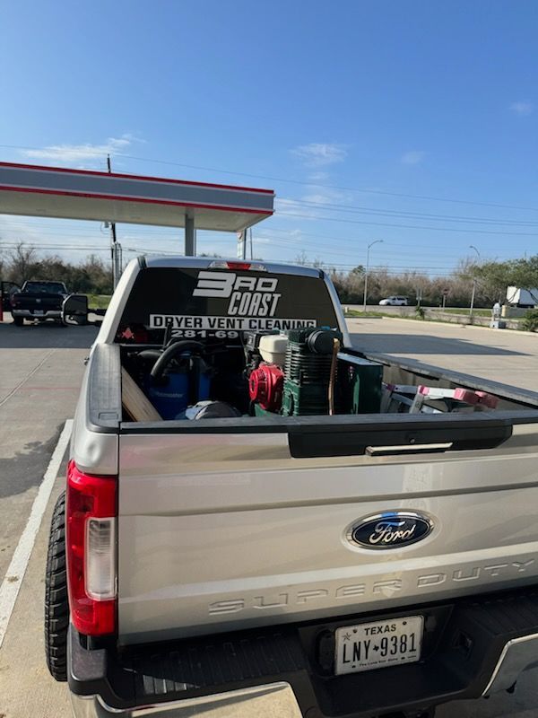 Silver Ford truck at a gas station with a 