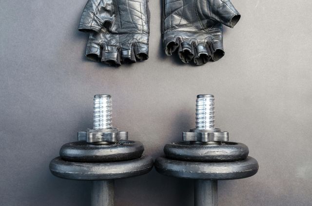 A pair of gloves and a pair of dumbbells on a table