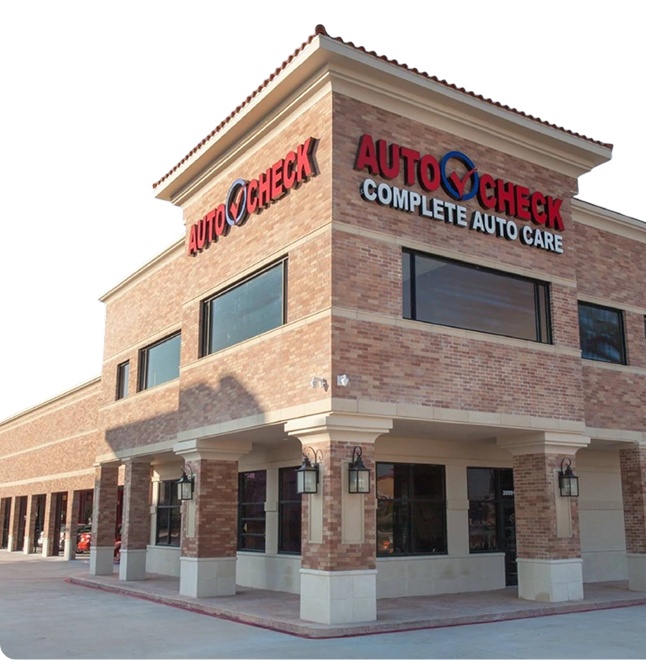 Auto Check complete auto care building with red brick facade, blue and red sign. | Auto Check Elite