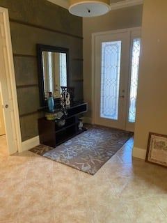 A hallway with a mirror and a rug in front of a door.
