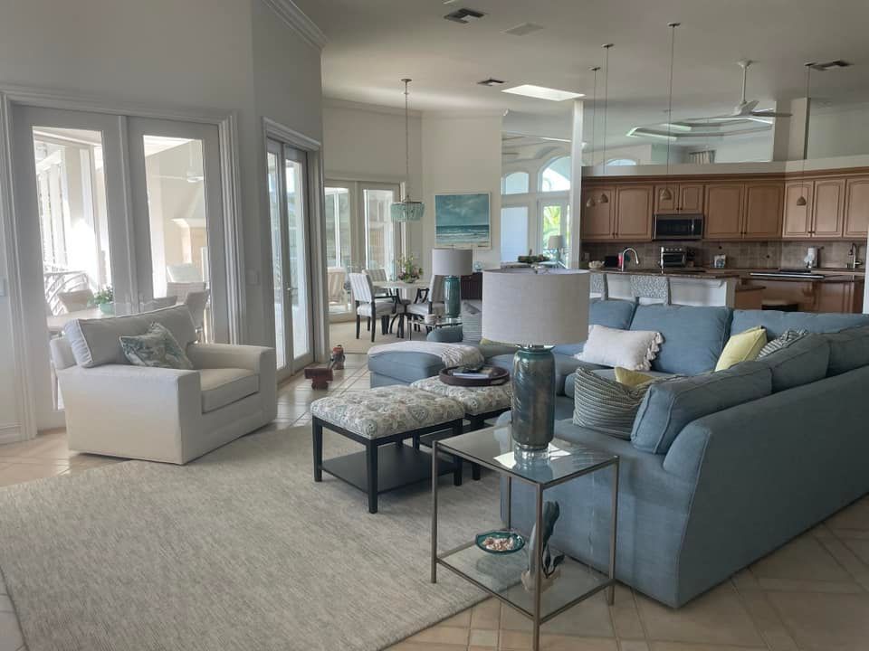 A living room with a blue couch and a white chair.