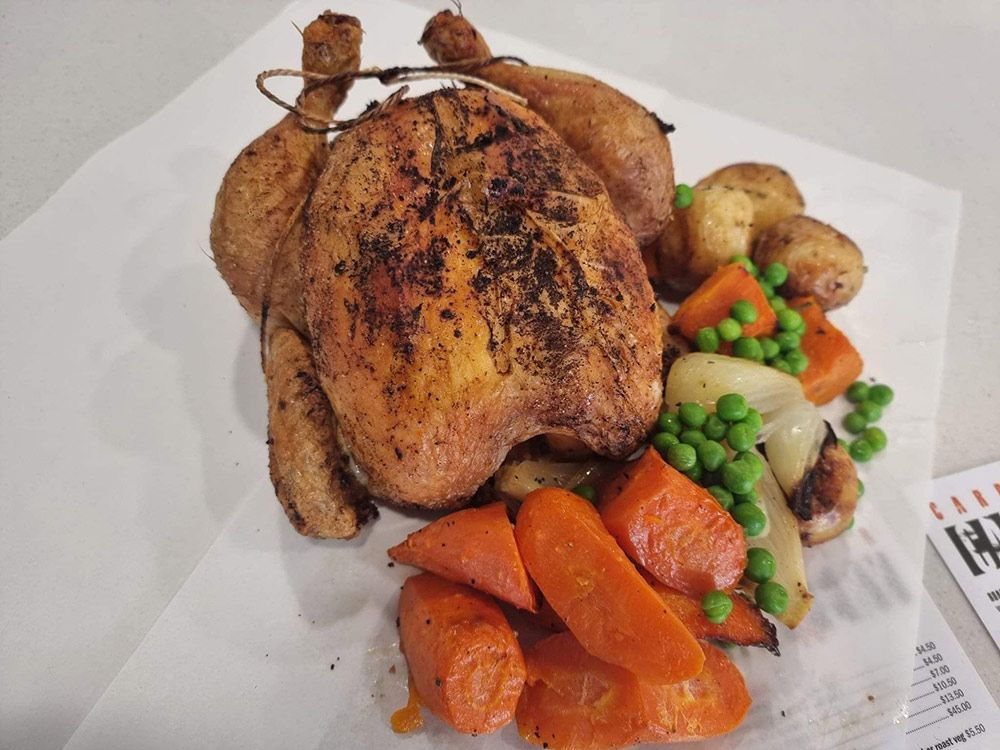 A Roasted Chicken With Carrots and Peas on a Plate — Carpenter Carvery in Wendouree, VIC