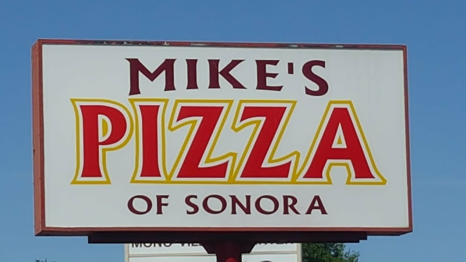 Mike’s Pizza of Sonora sign with red and yellow lettering on a white background