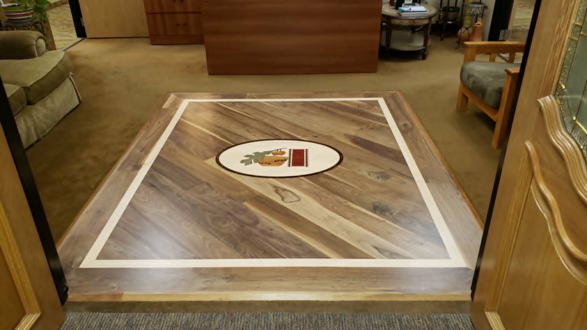 Wood-pattern floor inset with white border and center medallion in a living room entryway