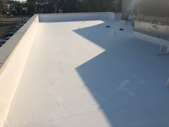 White flat roof with sunlight casting large shadow; outdoor setting.
