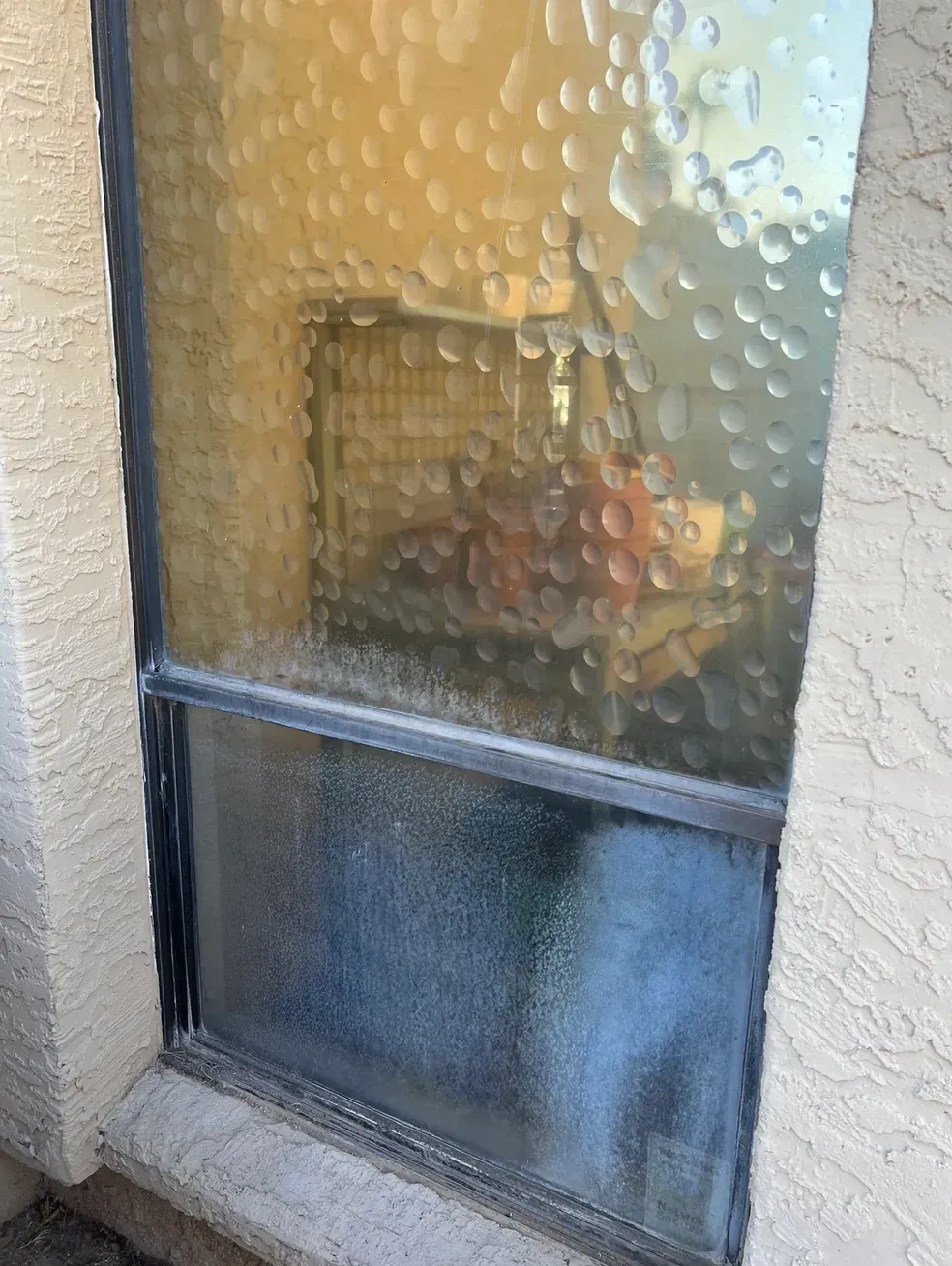 A window with a lot of water drops on it.