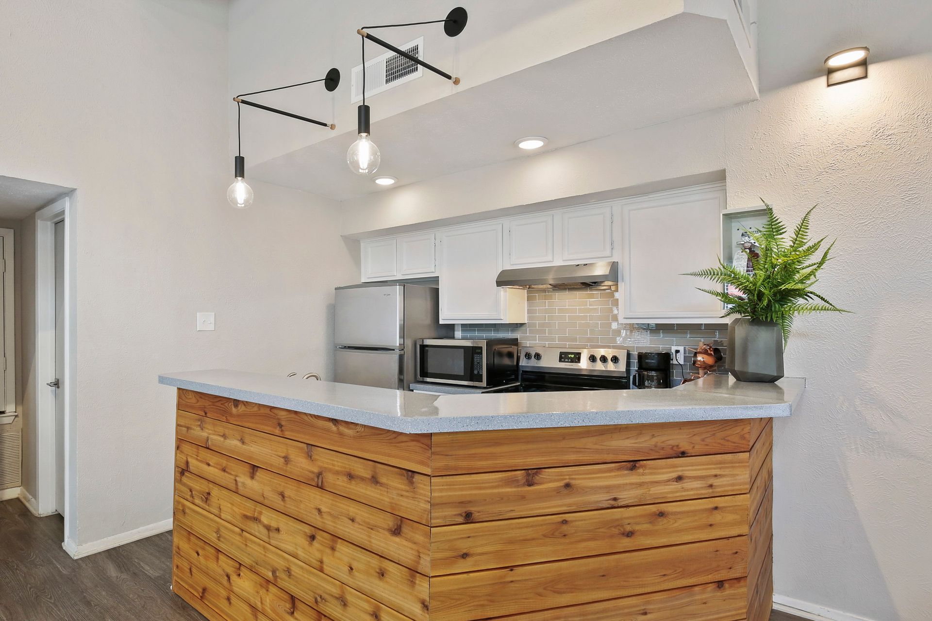Kitchen with wooden island, stainless steel appliances, and white cabinets.