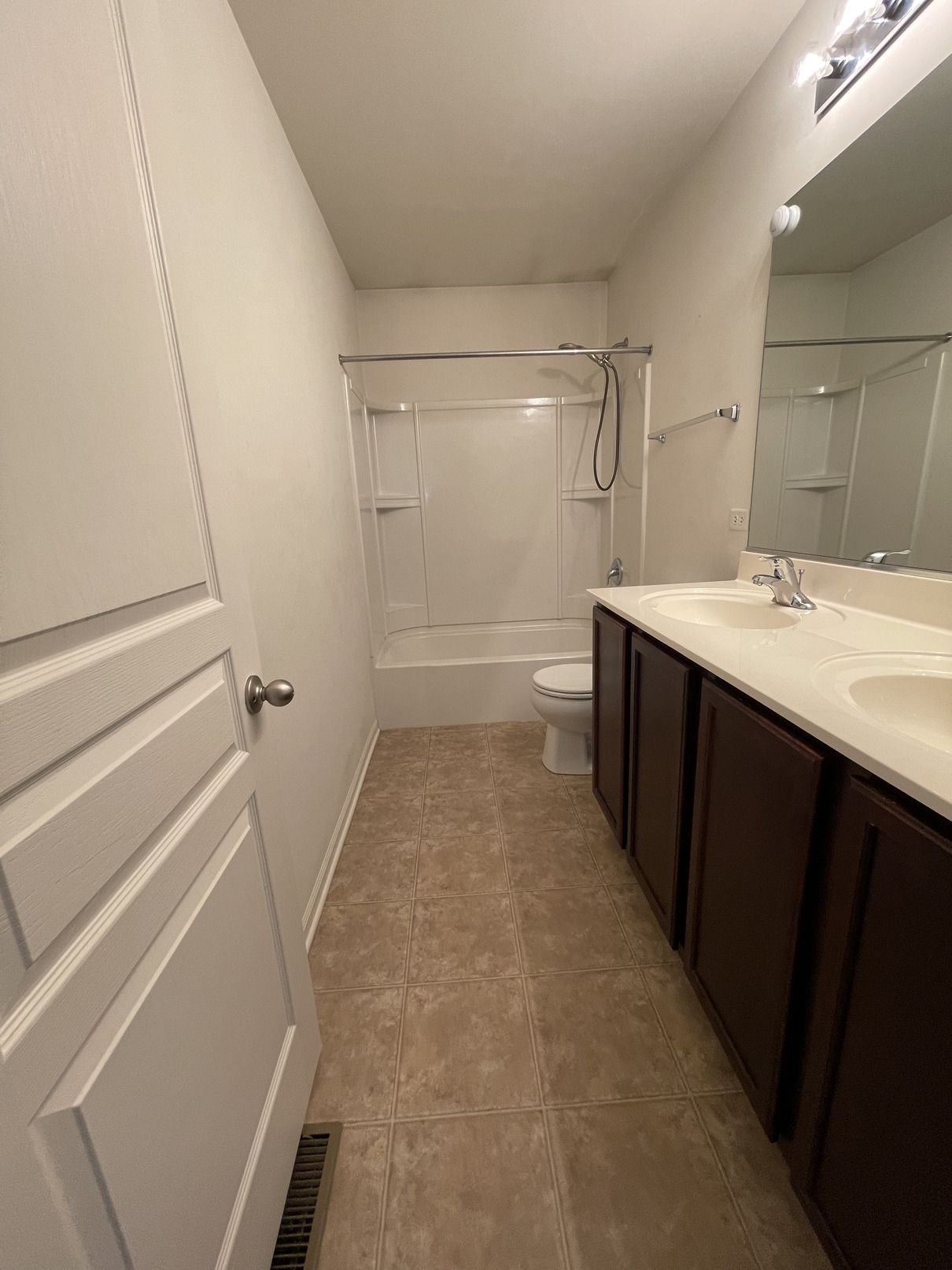 A bathroom with two sinks , a toilet , and a bathtub.