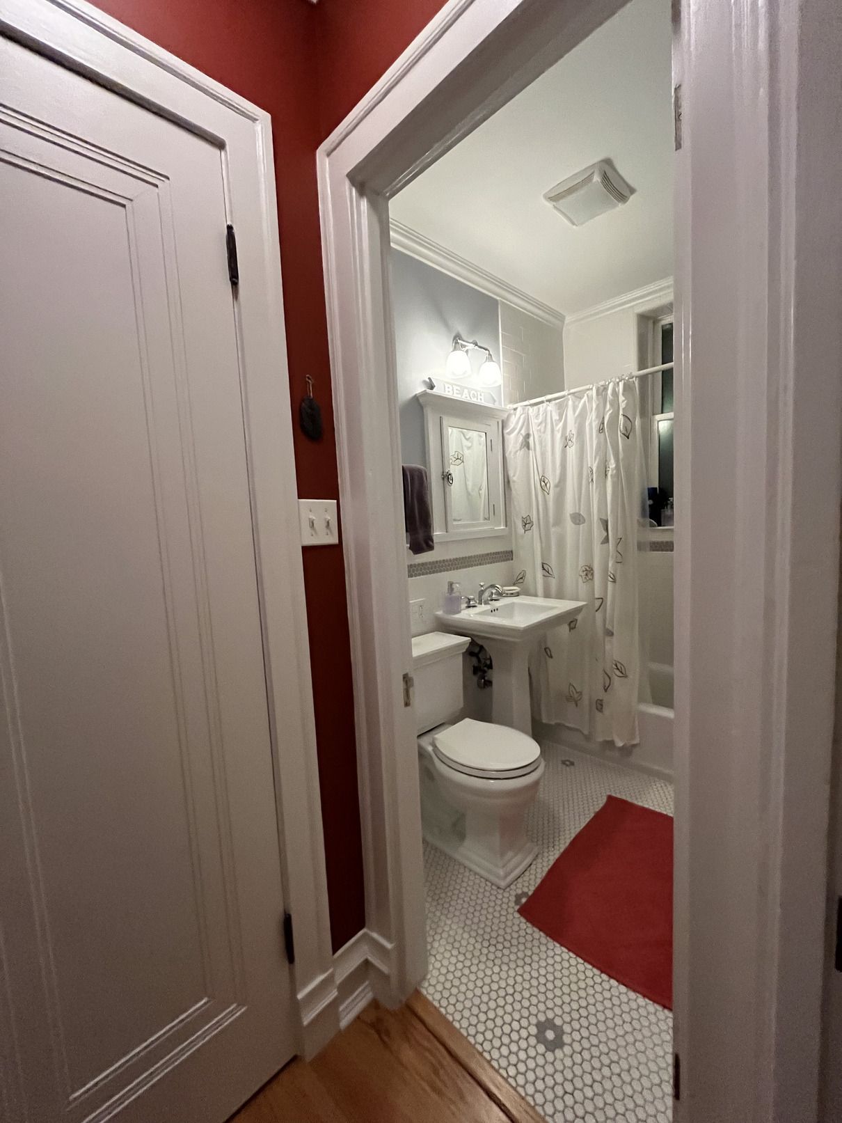 A bathroom with a toilet , sink and shower.