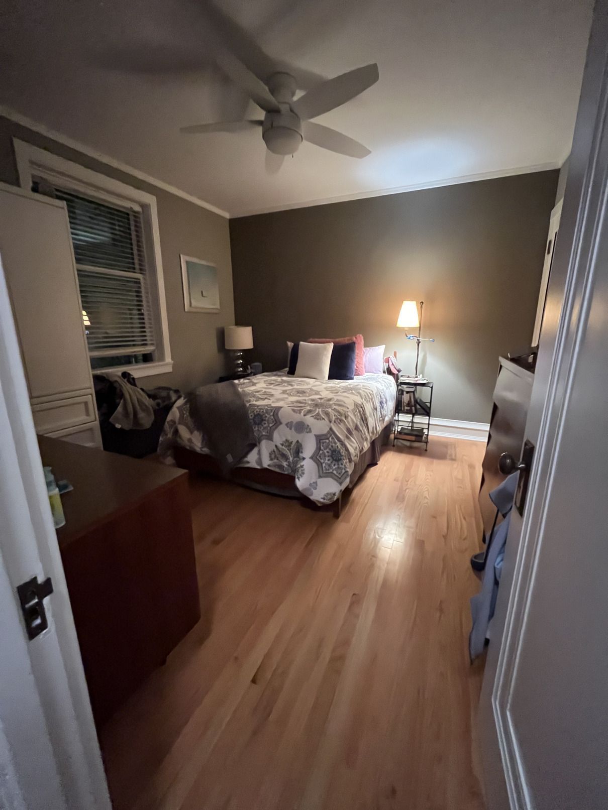 A bedroom with a large bed and a ceiling fan.
