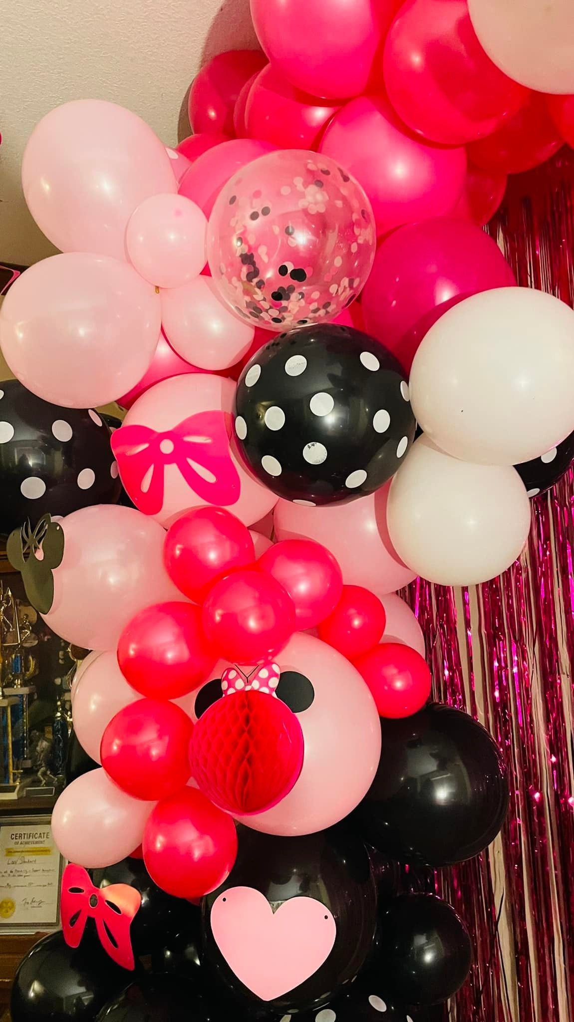 A bunch of pink and black balloons with a minnie mouse face on them