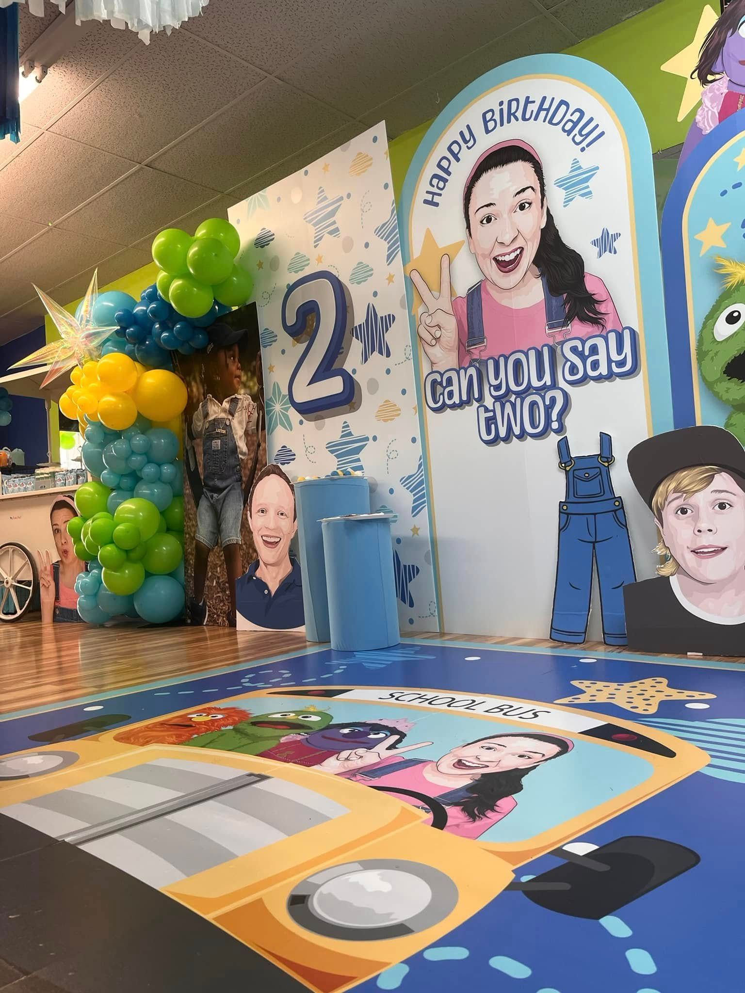 A room decorated for a child 's birthday with balloons and a frog.