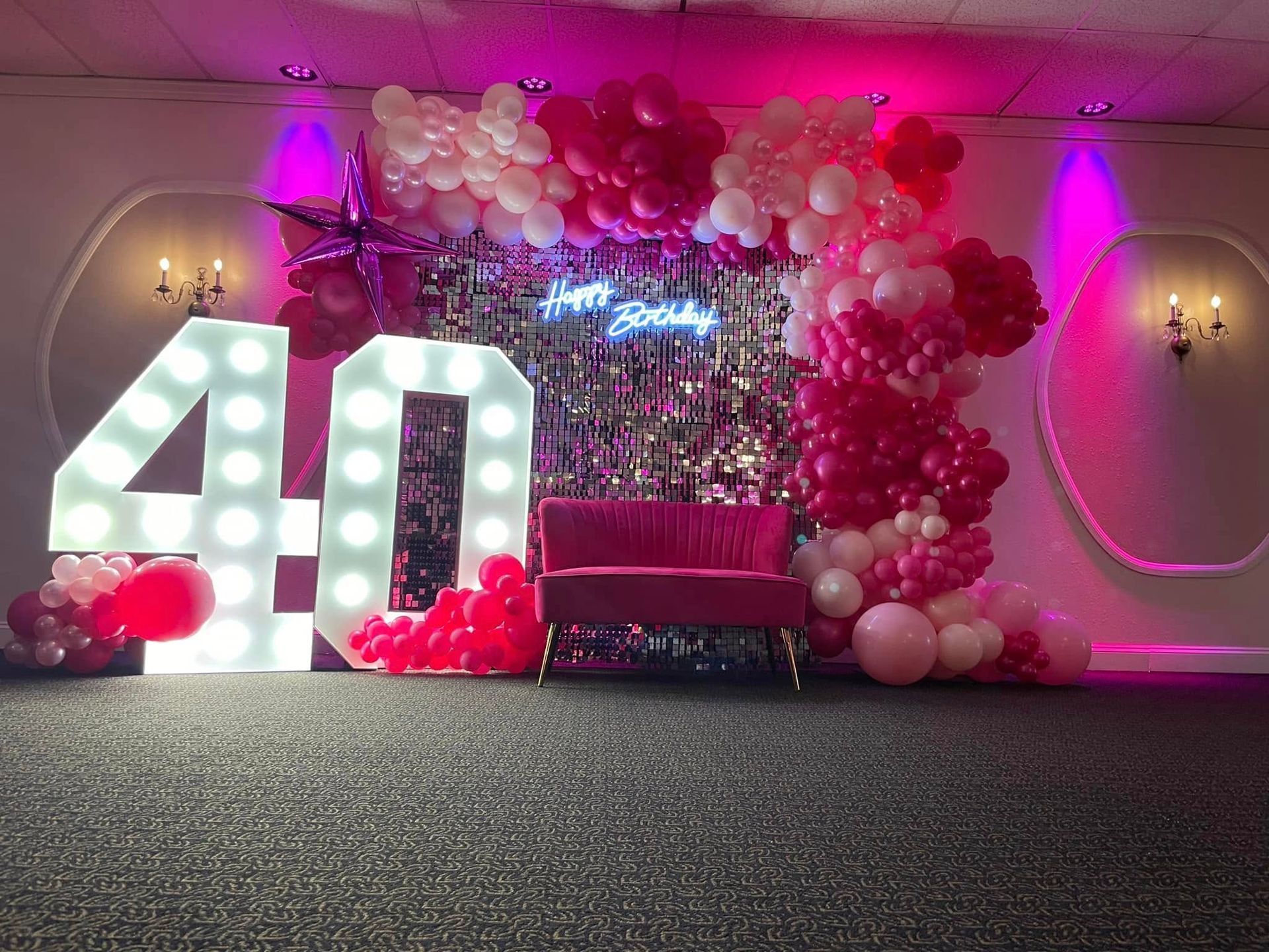 A room decorated with balloons and lights for a 40th birthday.