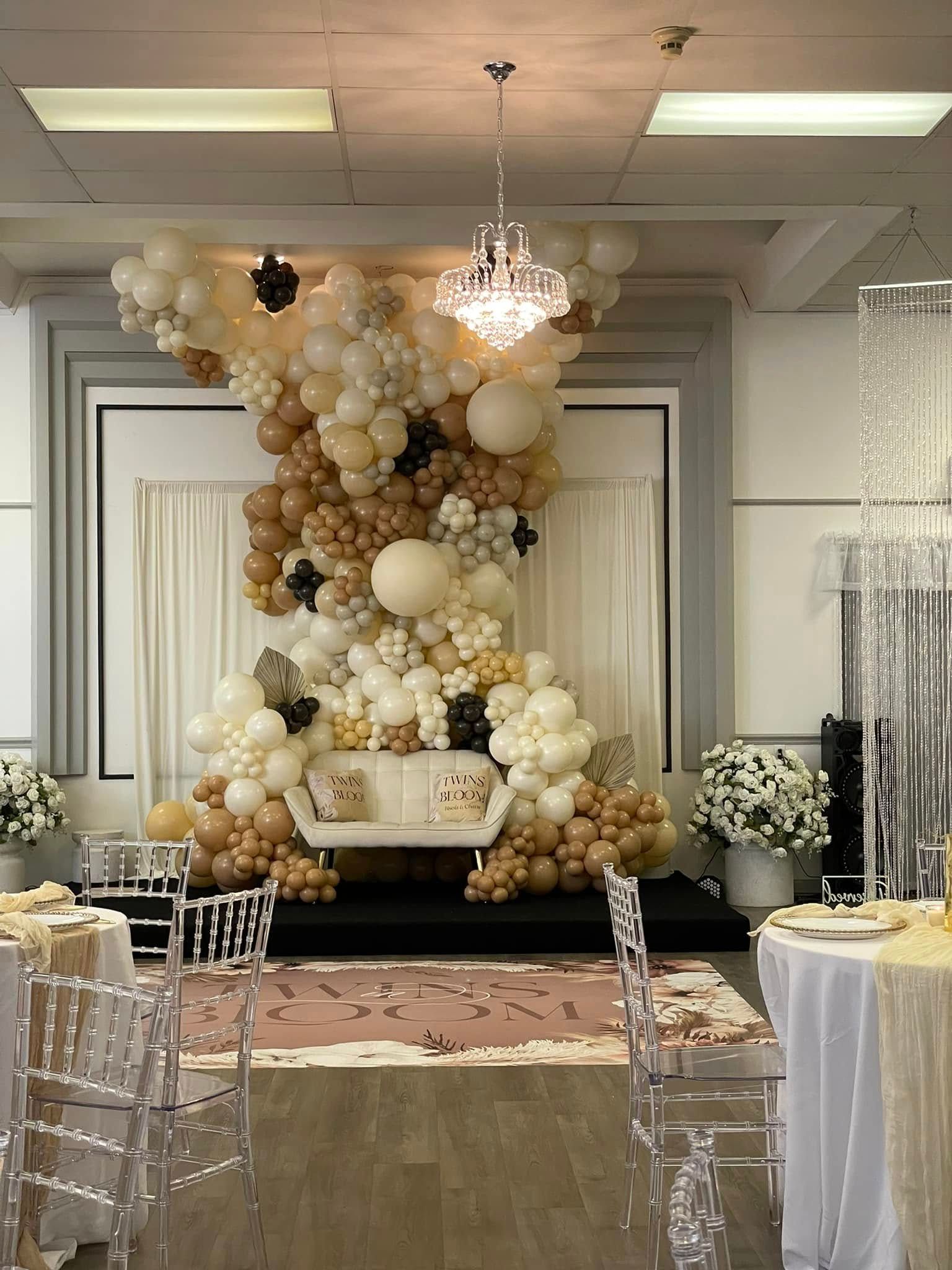 A room filled with tables and chairs and balloons.