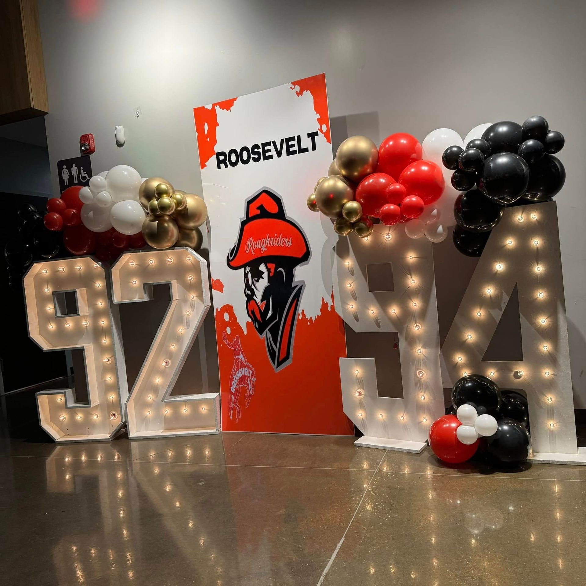 A sign that says roosevelt is surrounded by balloons and lights