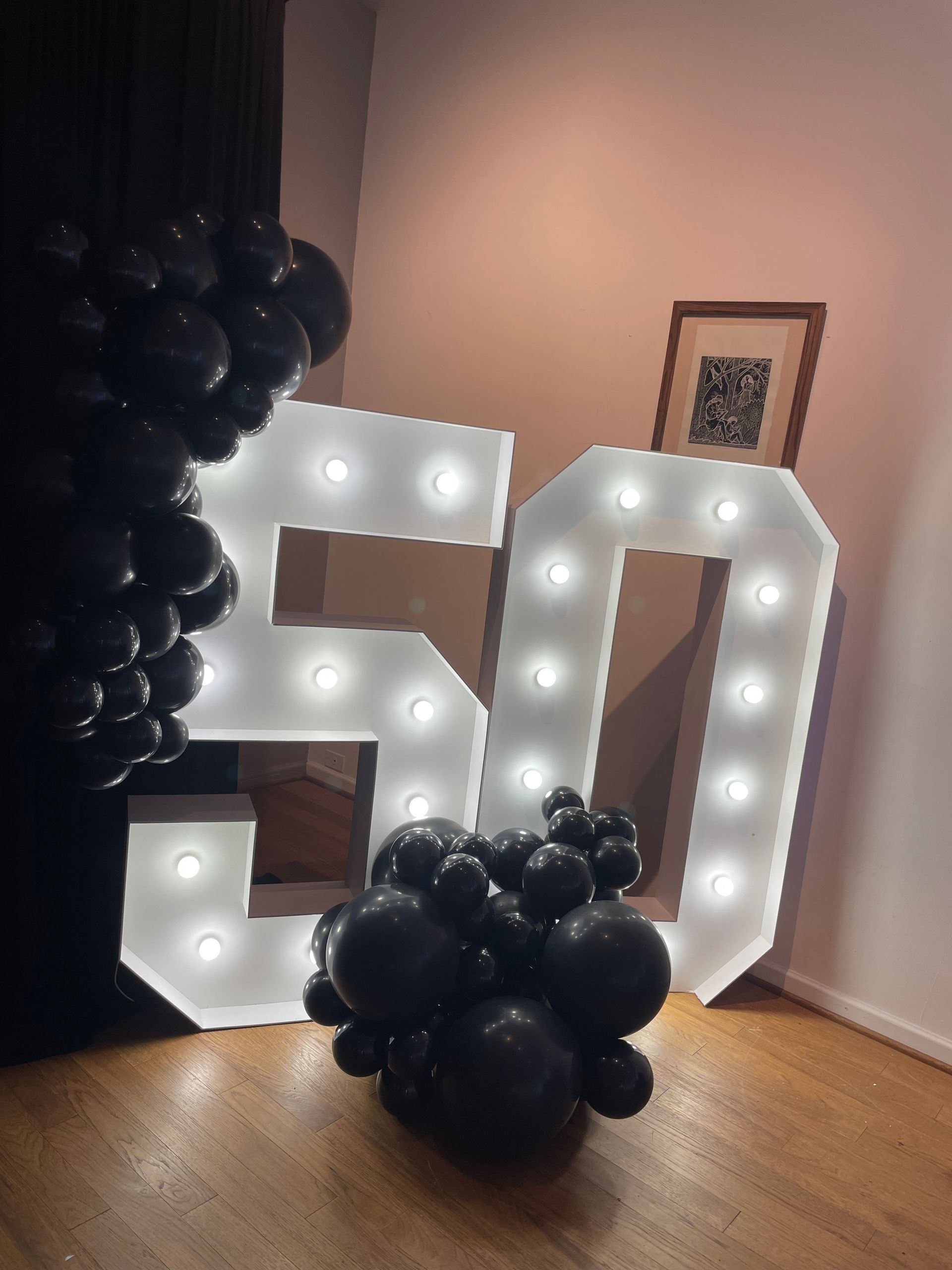 A large white number 50 is surrounded by black balloons.