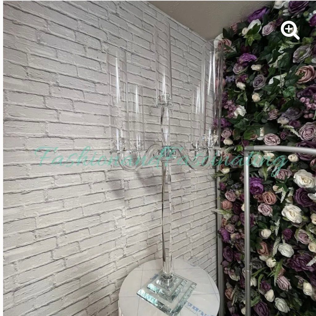 A room with a white brick wall and purple flowers on the wall.