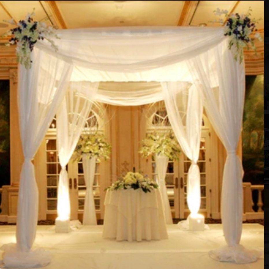 A white canopy over a table with flowers on it