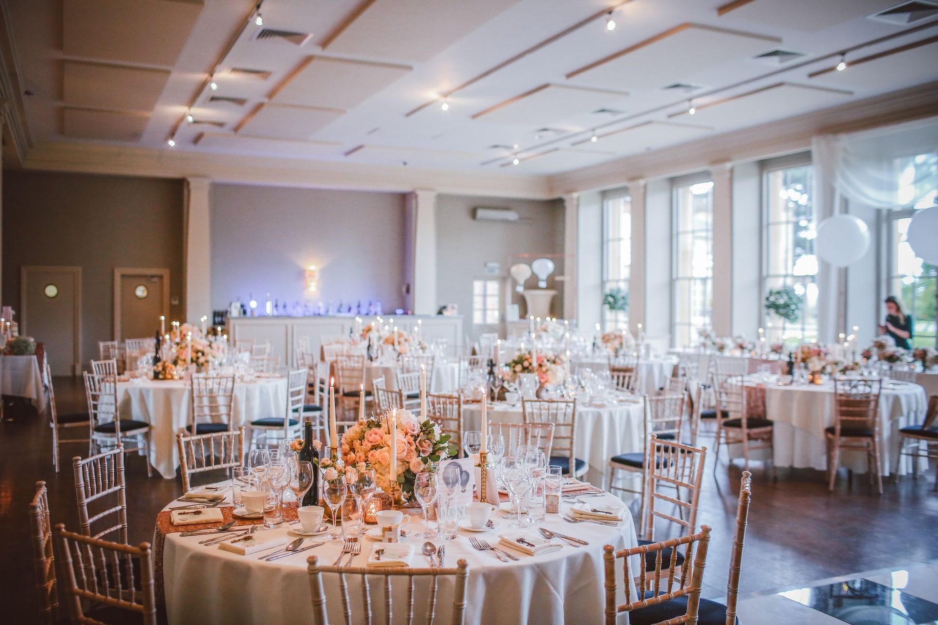 A large room with tables and chairs set up for a wedding reception.