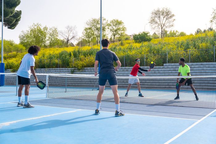 A group of men are playing tennis on a blue court