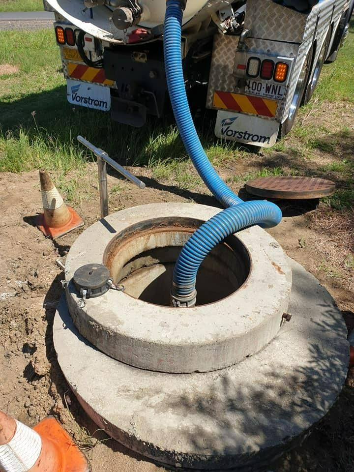 A Truck Is Pumping Water Into A Manhole Cover — Paap's Cleansing Services In Childers, QLD