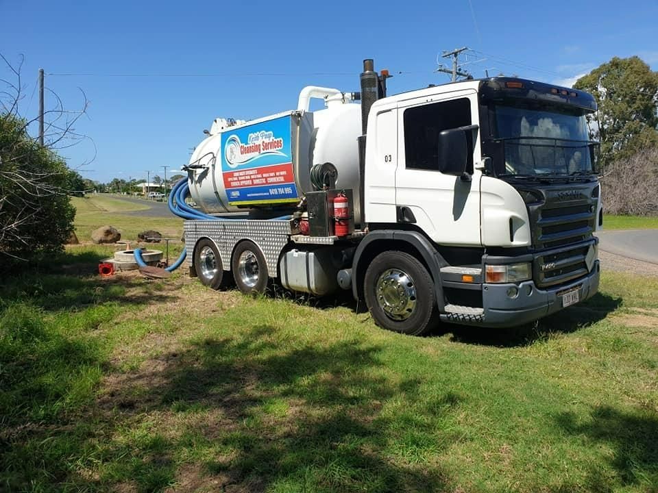 A White Vacuum Truck Is Parked In The Grass On The Side Of The Road — Paap's Cleansing Services In Childers, QLD