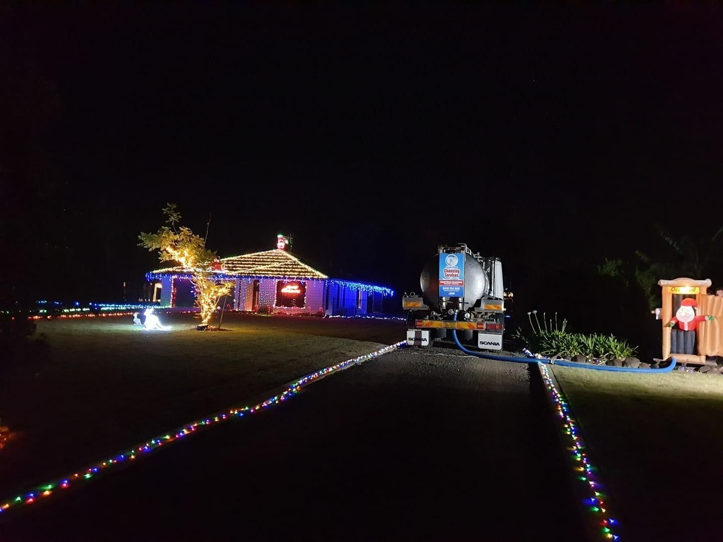 A House Decorated With Christmas Lights Is Lit Up At Night — Paap's Cleansing Services In Childers, QLD
