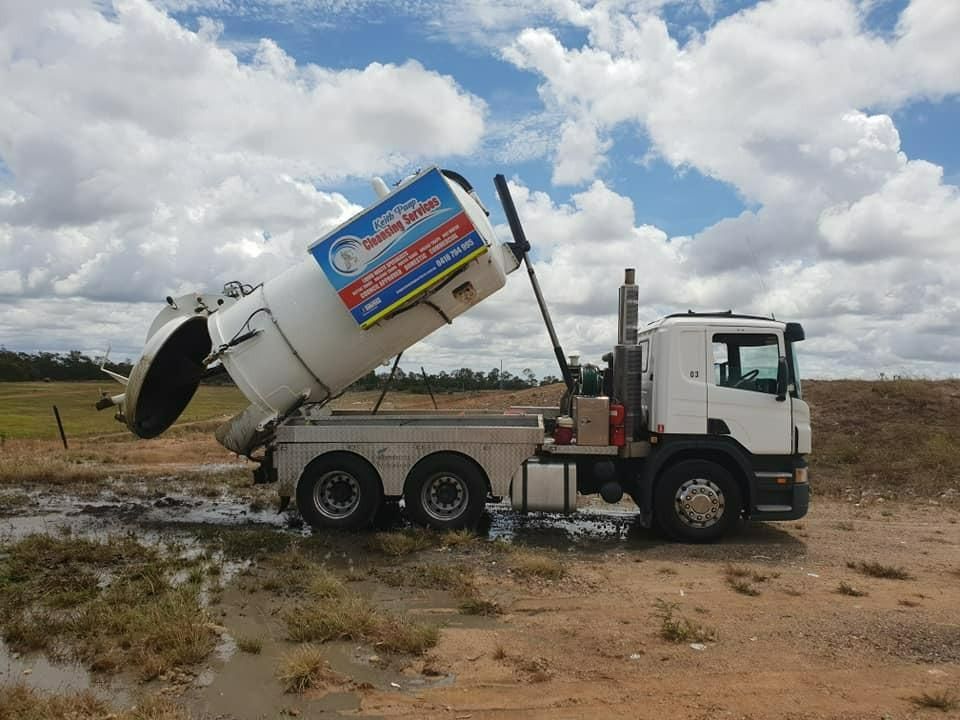 A White Vacuum Truck Is Parked In A Muddy Field — Paap's Cleansing Services In Gin Gin, QLD