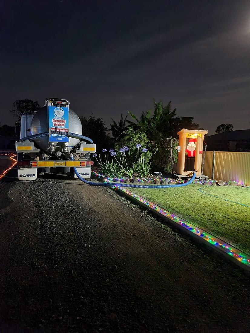 A Vacuum Truck Is Parked In Front Of A House At Night — Paap's Cleansing Services In Bundaberg, QLD