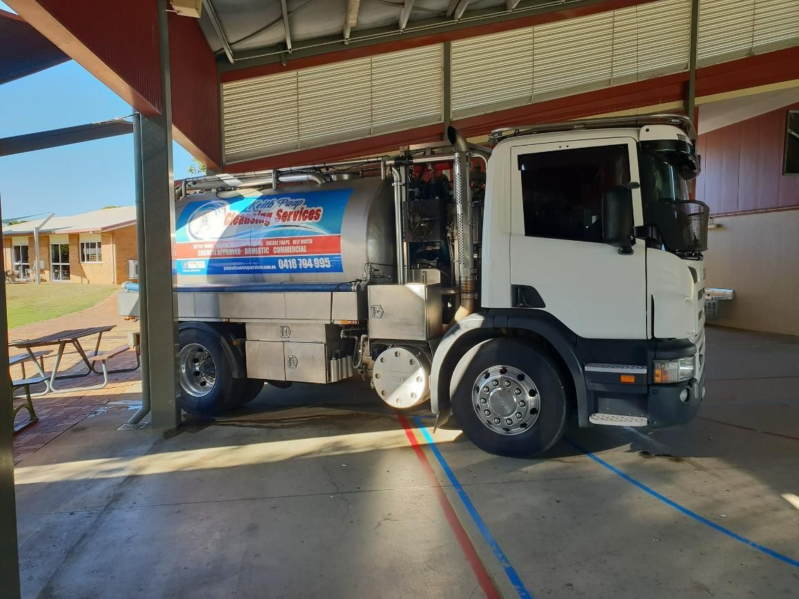 A White Truck Is Parked Under A Roof In A Parking Lot — Paap's Cleansing Services In Bundaberg, QLD