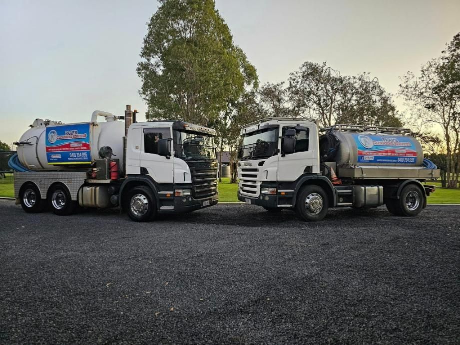 Two Trucks Are Parked Next To Each Other In A Parking Lot — Paap's Cleansing Services In Childers, QLD