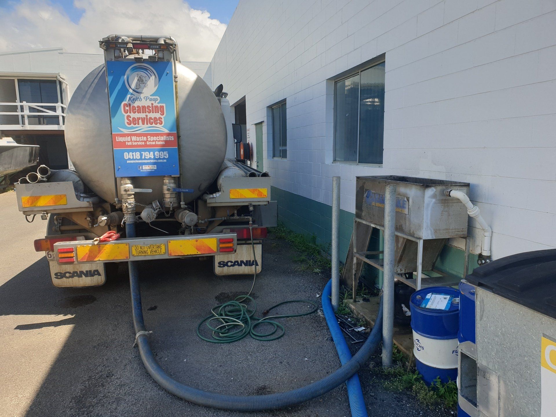 A Tanker Truck Is Parked In Front Of A Building — Paap's Cleansing Services In Branyan, QLD