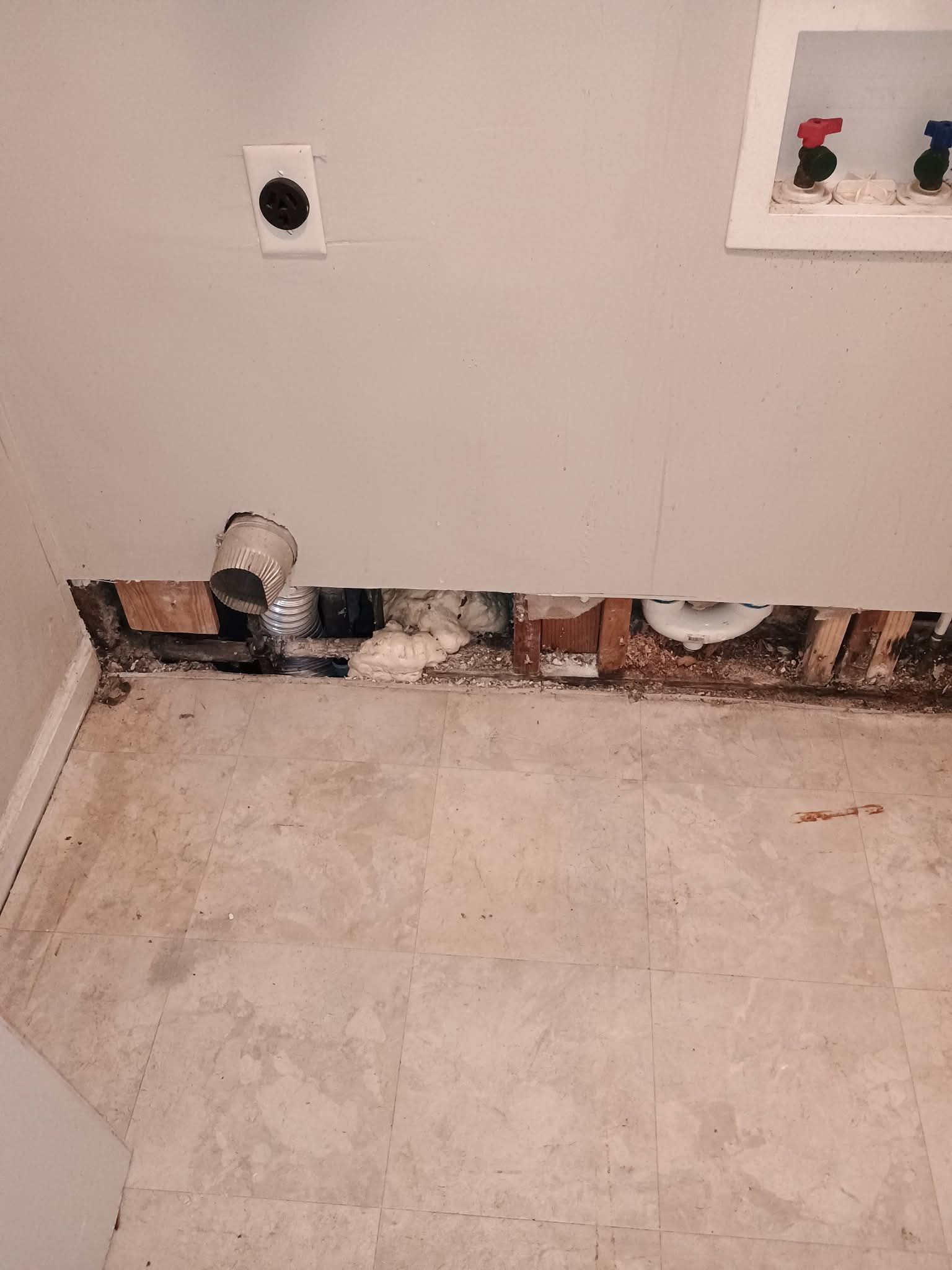 A bathroom with a hole in the wall and a hole in the floor.